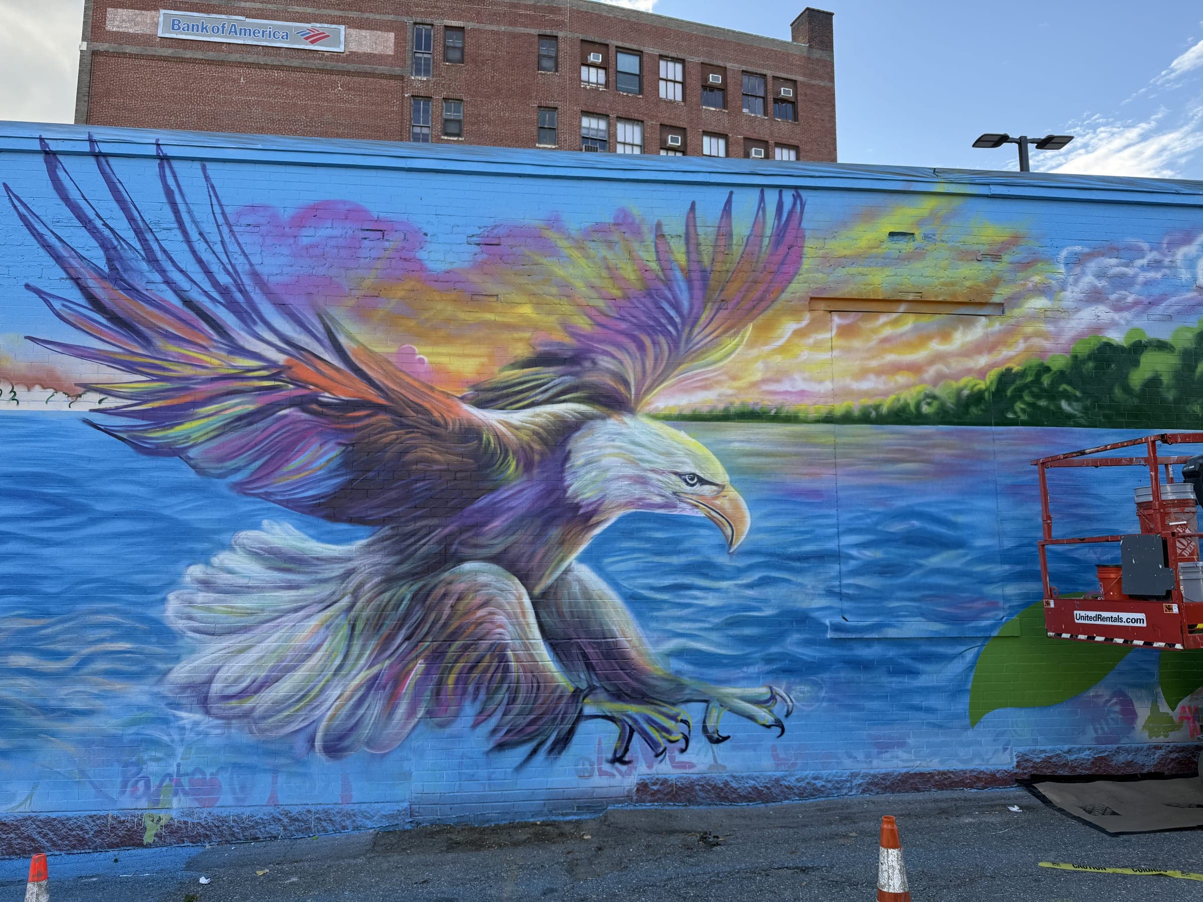 The finished Currents of Strength mural: a bald eagle sweeping over the Merrimack River, painted across a downtown Haverhill wall.