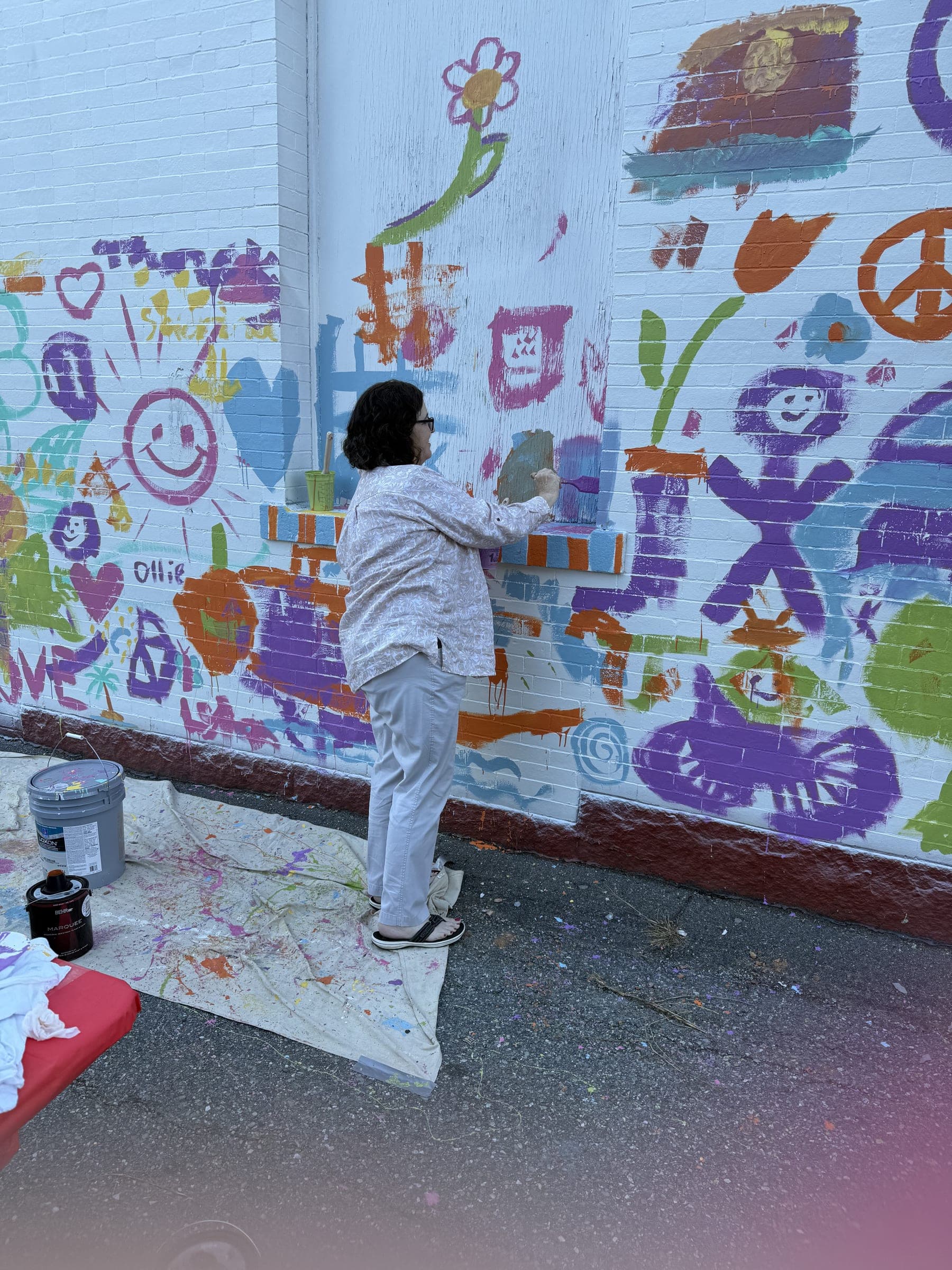 Painters adding their marks to the community wall at the Haverhill paint day.